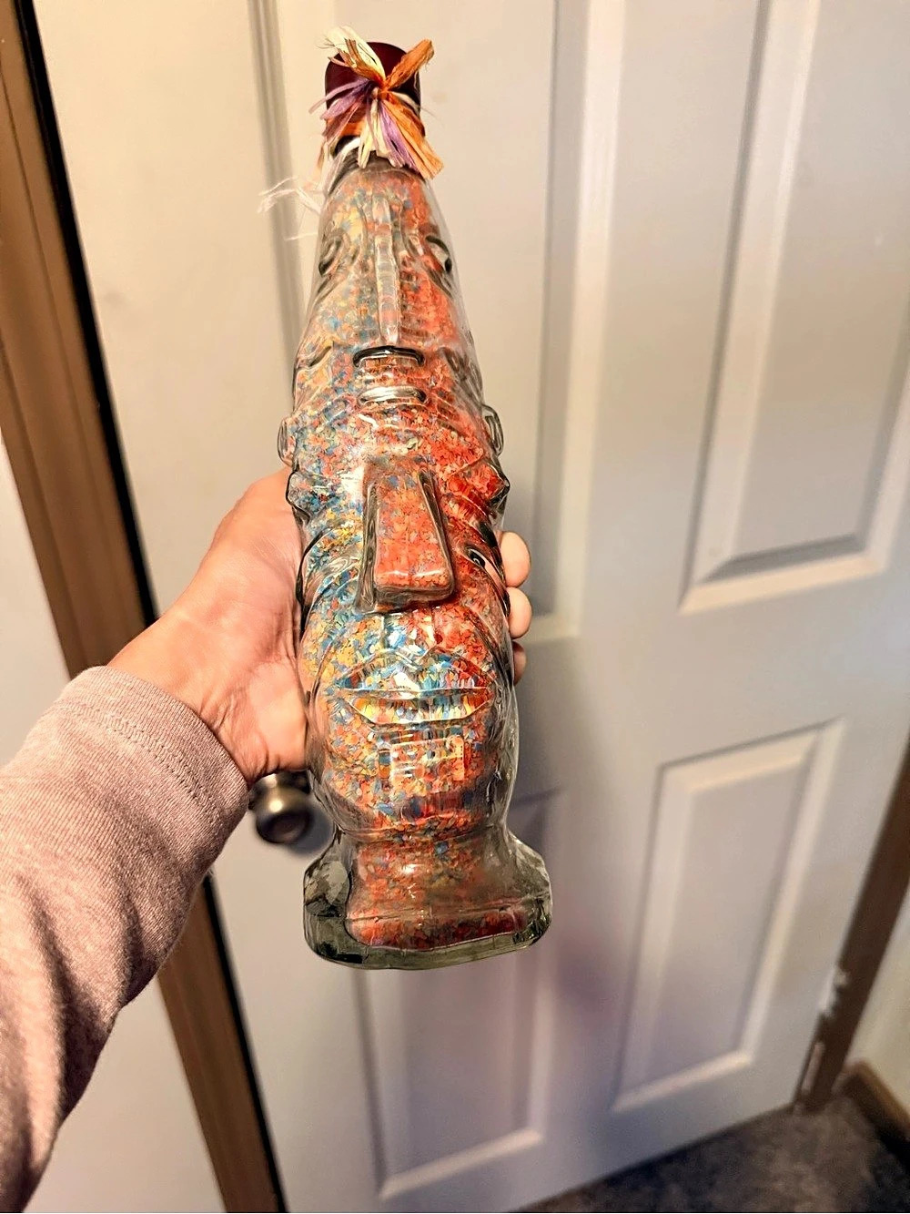 Tiki Face Glass Decorative Bottle with Stopper & Raffia Approx. 11”